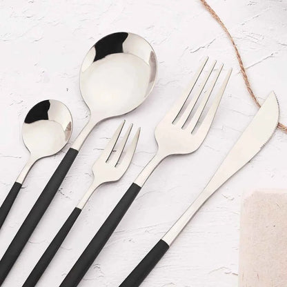 Détail des couverts bicolores noir et argent : zoom sur le couteau, la fourchette et les cuillères en acier inoxydable au design minimaliste