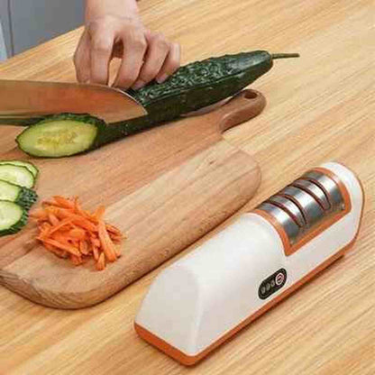 Aiguiseur électrique UltraSharp posé sur un plan de travail à côté de légumes finement tranchés pour illustrer la précision de l'affûtage.