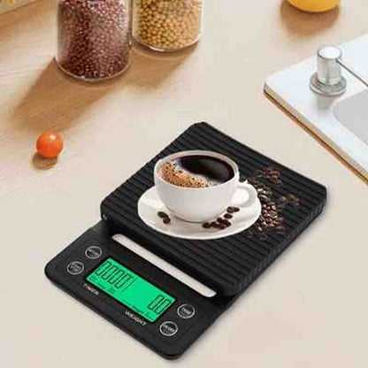 Tasse de café blanc posée sur la balance noire Précision Gram avec écran rétroéclairé vert, idéale pour le dosage précis du café.