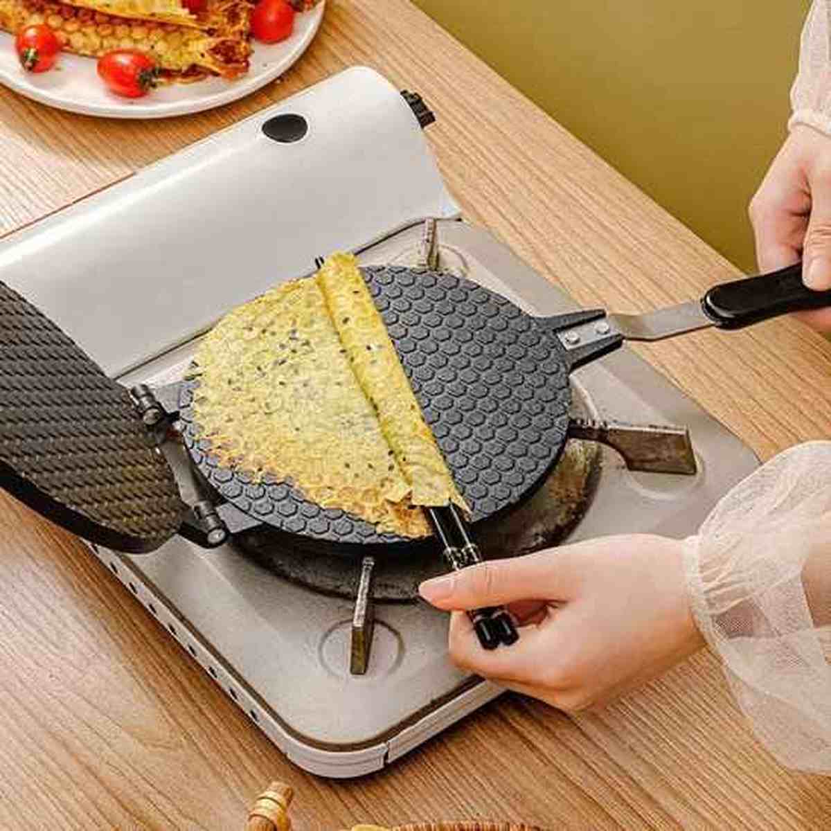 Pliage d'une crêpe fine et dorée sur la plaque chauffante texturée de la crêpière électrique HautPerformance.
