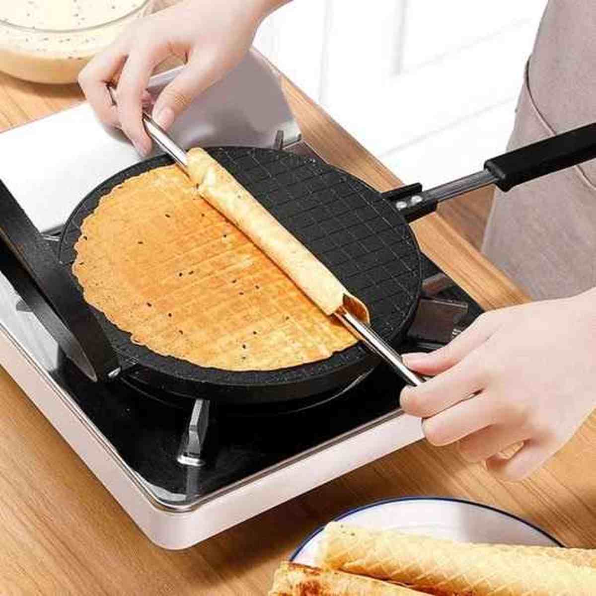 Enroulage d'une gaufrette croustillante à l'aide d'un bâtonnet sur la plaque de la crêpière HautPerformance.