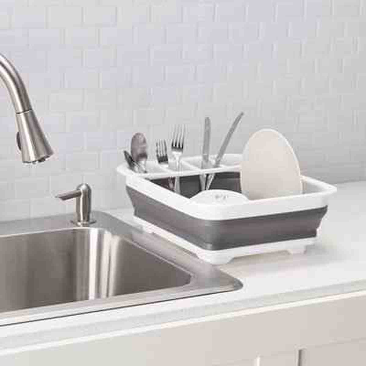 Égouttoir à vaisselle blanc et gris Compact Kitchen installé sur le rebord d'un évier en inox pour un séchage gain de place