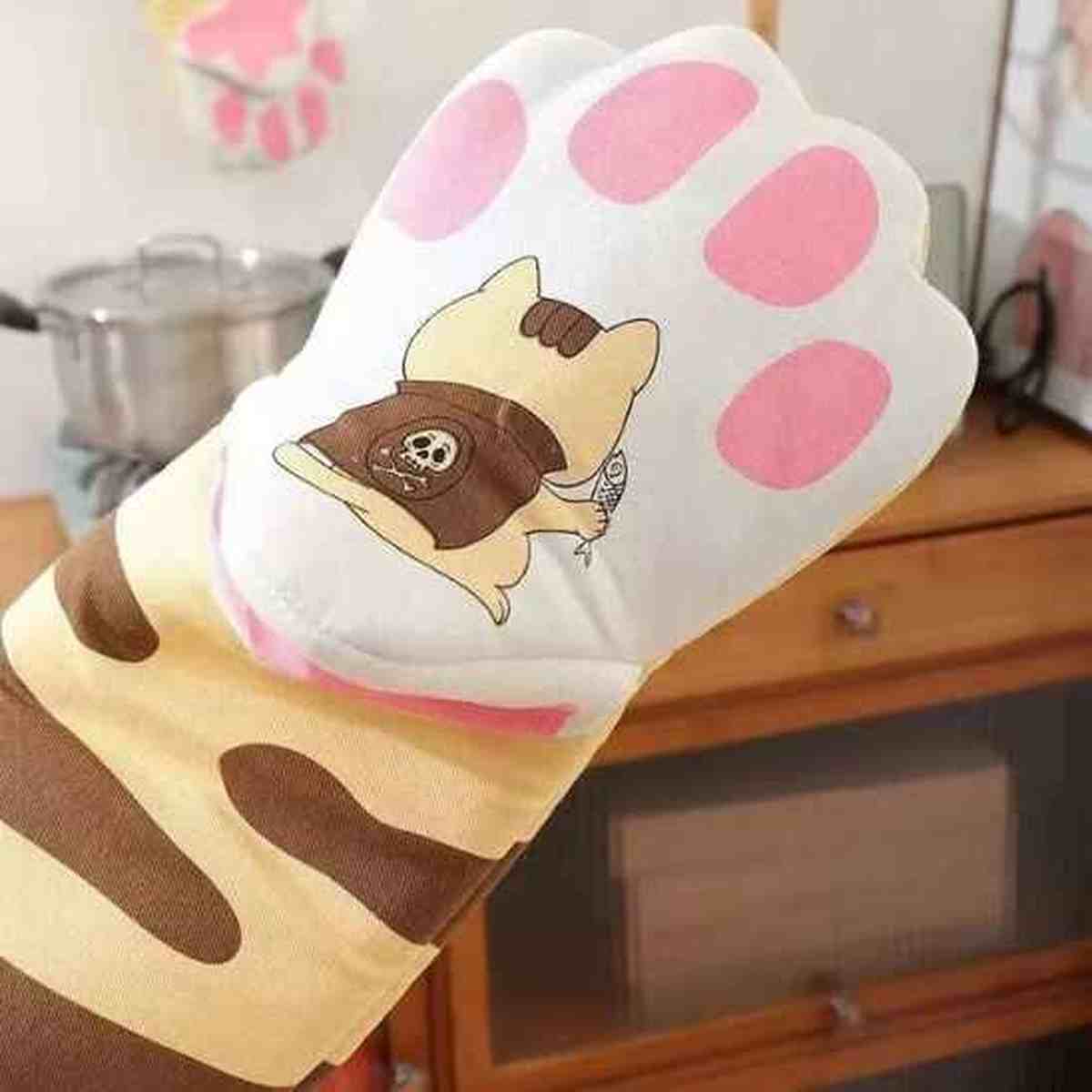 Détail d'un gant de cuisine beige avec un motif de patte de chat rose et une illustration de chat cuisinier, alliant style et protection thermique