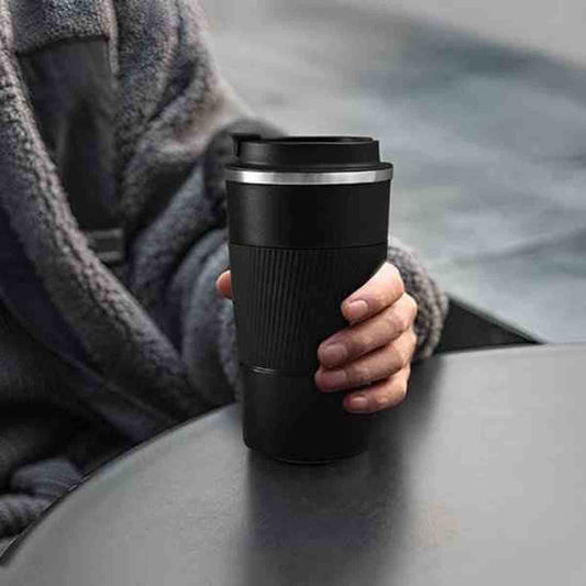 Gourde isotherme ThermoFlex noire en acier inoxydable posée sur une table, montrant sa base stable et son design épuré.