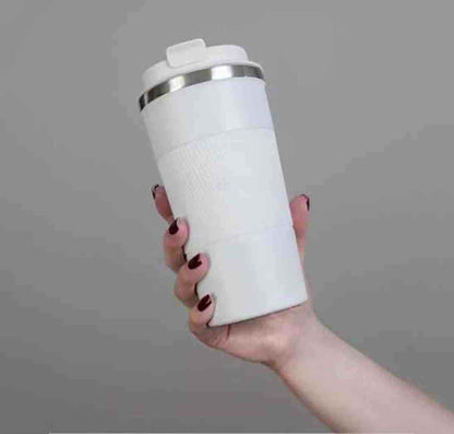 Main tenant une gourde isotherme ThermoFlex blanche ouverte, révélant le goulot en acier inoxydable de haute qualité.