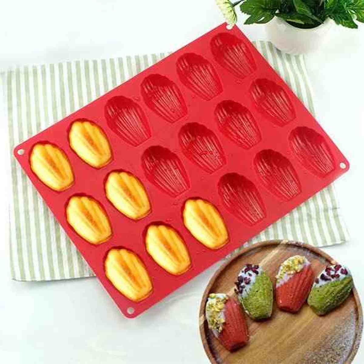 Moule à madeleines PâtissiPro en silicone rouge avec 12 cavités, présenté avec des madeleines nature et décorées pour illustrer la qualité de cuisson.