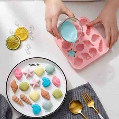Moule en silicone rose PâtissiPro utilisé pour créer des chocolats et mini-gâteaux en forme de coquillages, avec un aperçu du résultat final coloré dans une assiette