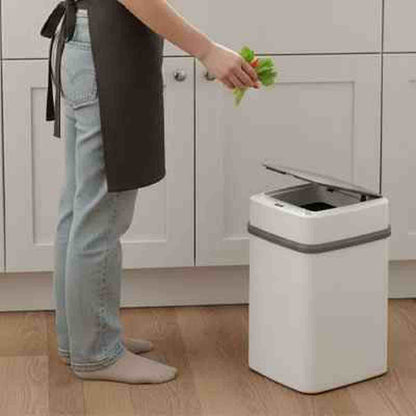 Poubelle de cuisine automatique blanche Design Fresh avec couvercle ouvert, utilisée pour jeter des légumes dans une cuisine moderne.