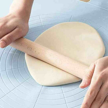 Rouleau à pâtisserie en bois massif Artisan Pro étalant une pâte sur un tapis de cuisson bleu gradué pour une précision de diamètre parfaite.
