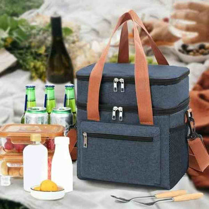 Sac isotherme bleu OrganiFlex avec poignées marron, entouré de couverts et récipients sur une table de pique-nique en extérieur.