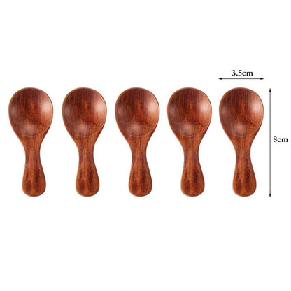 Alignement de cinq mini cuillères de dosage en bois naturel posées sur une surface en bois brut, montrant la finition lisse et artisanale.