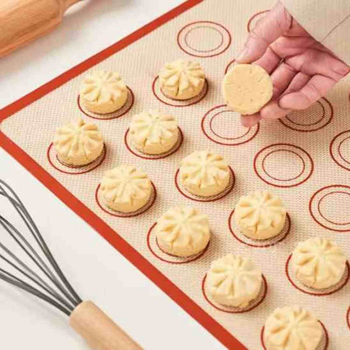 Biscuits sablés posés sur le tapis de cuisson silicone PâtissiPro, illustrant la surface antiadhésive qui permet un décollage facile sans ajout de matière grasse.