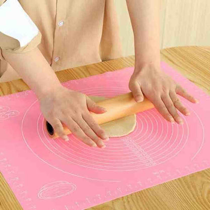 Utilisation d'un rouleau à pâtisserie sur le tapis de pétrissage rose PâtissiPro, idéal pour une session de pâtisserie relaxante et précise grâce aux graduations.