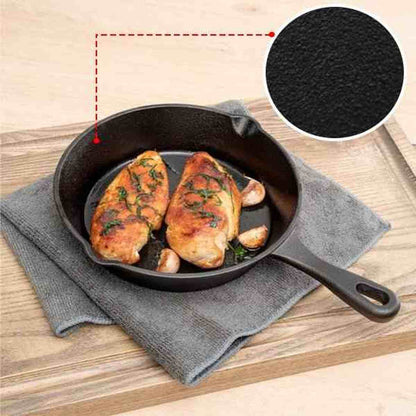 Gros plan sur le grain de la fonte noire DuraCook avec deux blancs de poulet rôtis et gousses d'ail dans la poêle.